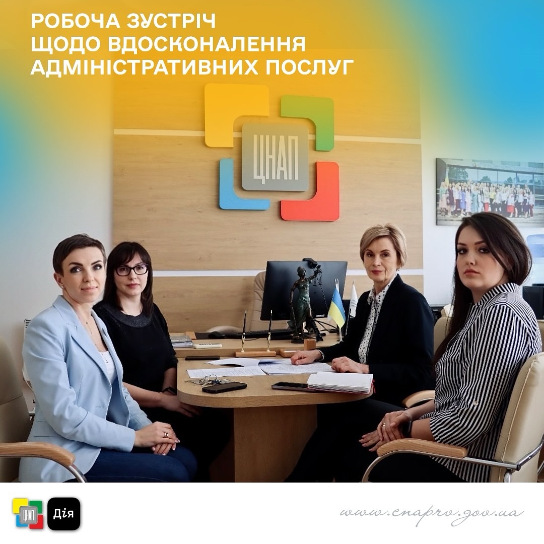 Чотири жінки за столом ведуть ділову дискусію, на столі документи, смартфон і окуляри